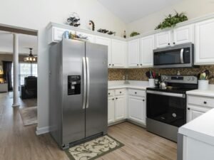 Bright kitchen showcasing stainless steel appliances and white cabinets.