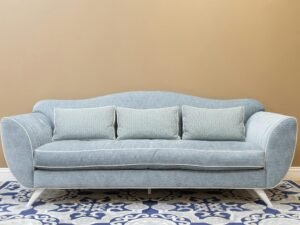 Stylish blue sofa with cushions on patterned carpet, perfect for a modern, cozy living space.