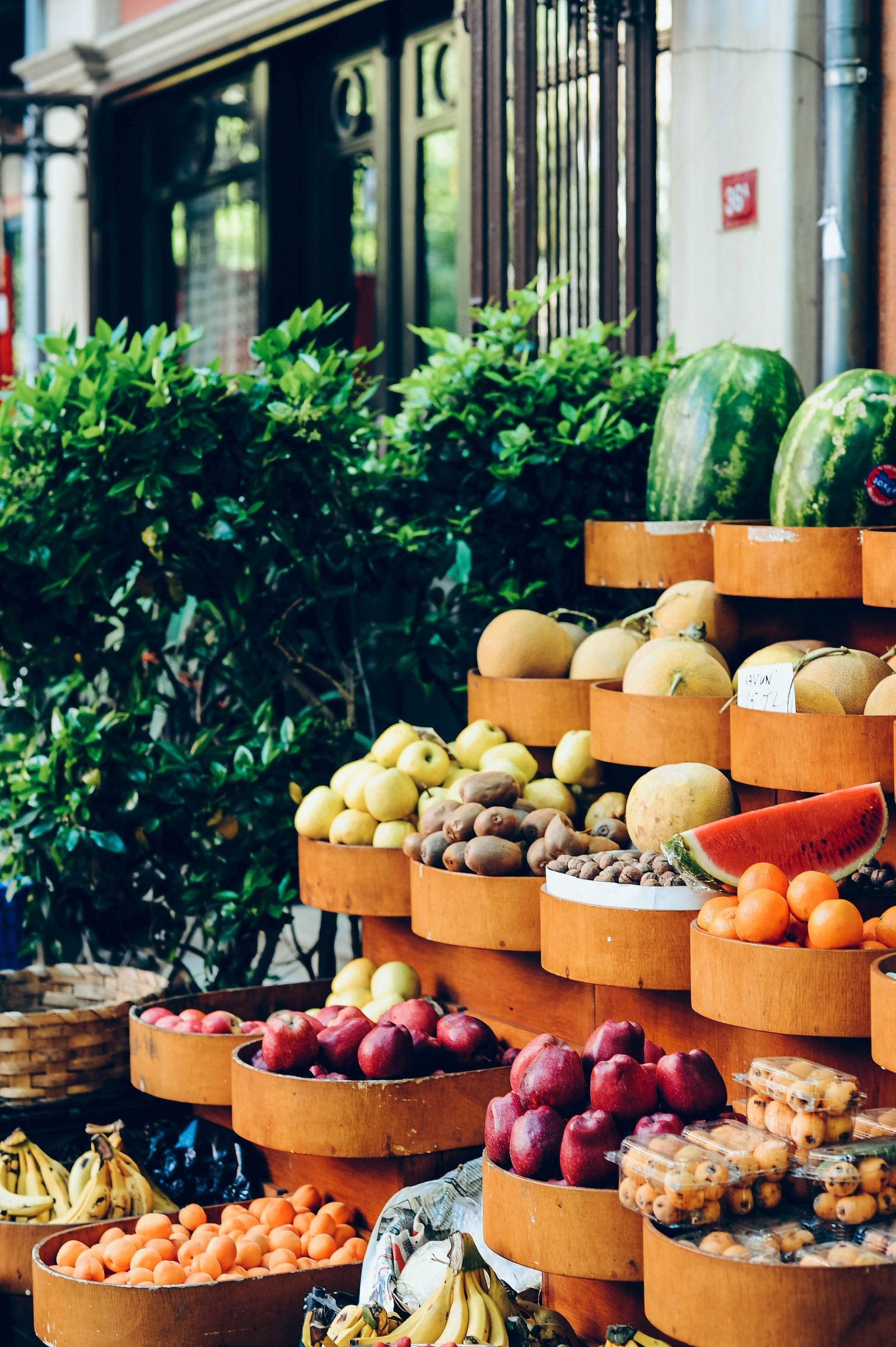 Colorful display of fresh fruits on an outdoor market stall, showcasing variety and abundance.