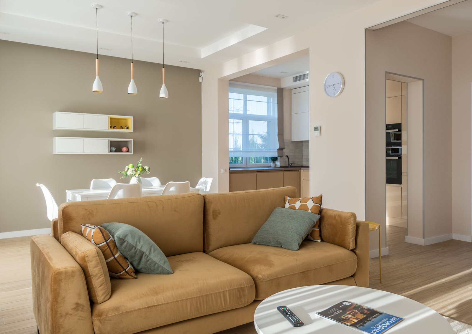 Spacious living room with a sofa, dining table, and modern kitchen design.